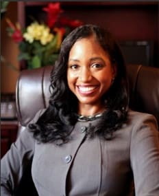 A woman sitting in an office chair smiling for the camera.